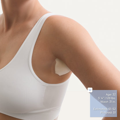 Close-up of a woman wearing a white sports bra with an underarm adhesive patch applied to the armpit with her arms lowered, on a light gray background. A blue text box on the right lists the model's measurements and estimated patch size.