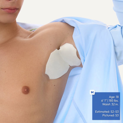 A close-up of a person's upper chest and shoulder wearing white adhesive underarm patch, with a light blue shirt draped off the shoulder. A blue text box in the lower right lists model information.
