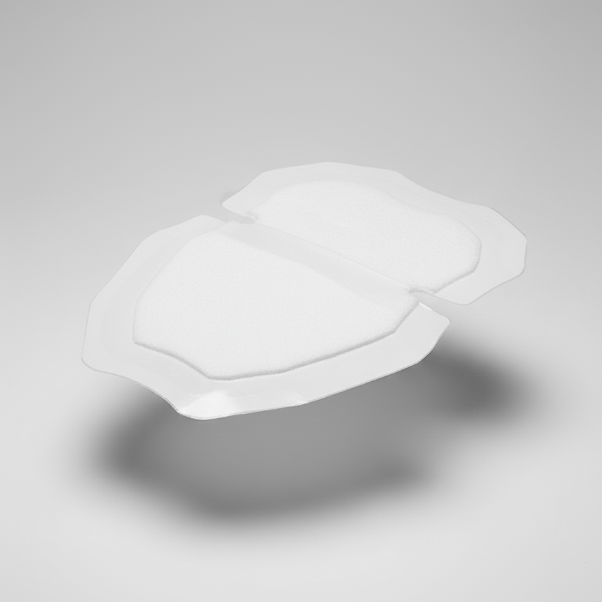 A sweat adhesive patch, with the clear inner liners still on, shown on a neutral background to highlight the product's shape.